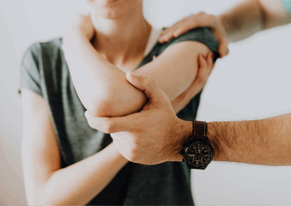 Mobilizzazione articolare dell’articolazione del gomito durante una seduta di fisioterapia post-frattura dell’omero, eseguita da un professionista specializzato della FisioClinic del Centro Colombo Genova