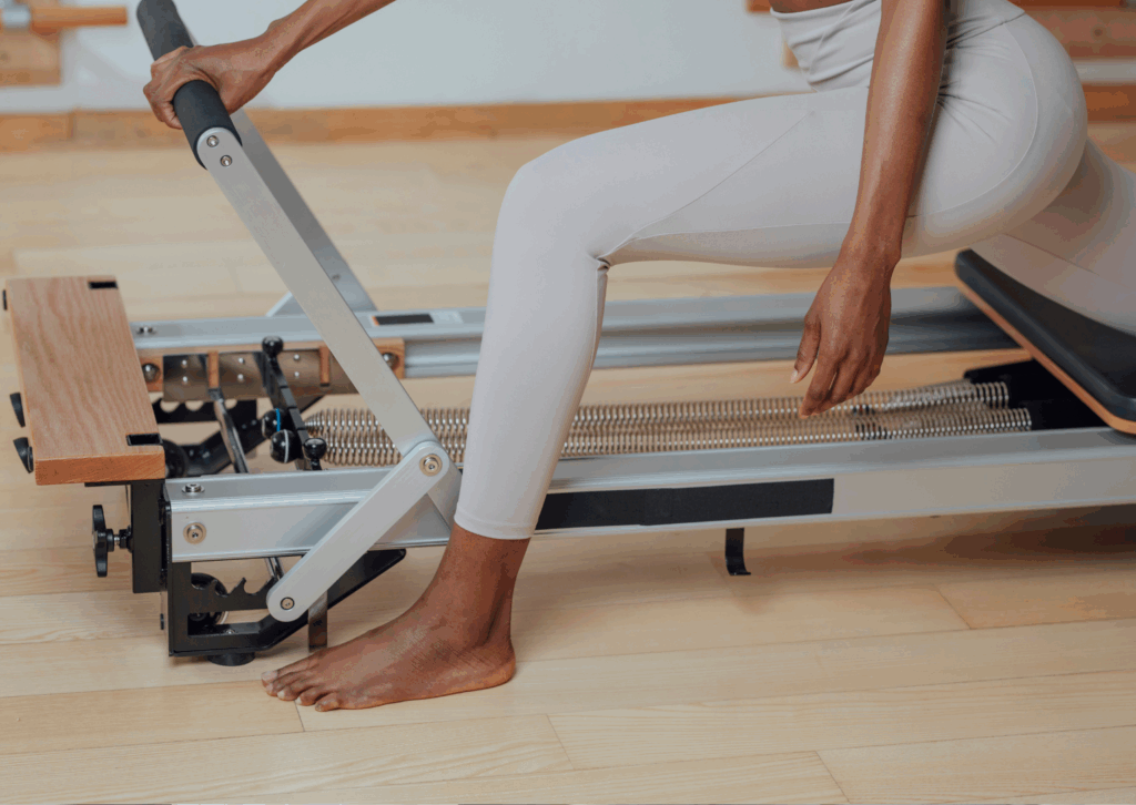 Paziente esegue esercizio di Pilates con Reformer in ambito fisioterapico presso la FisioClinic del Centro Colombo Genova