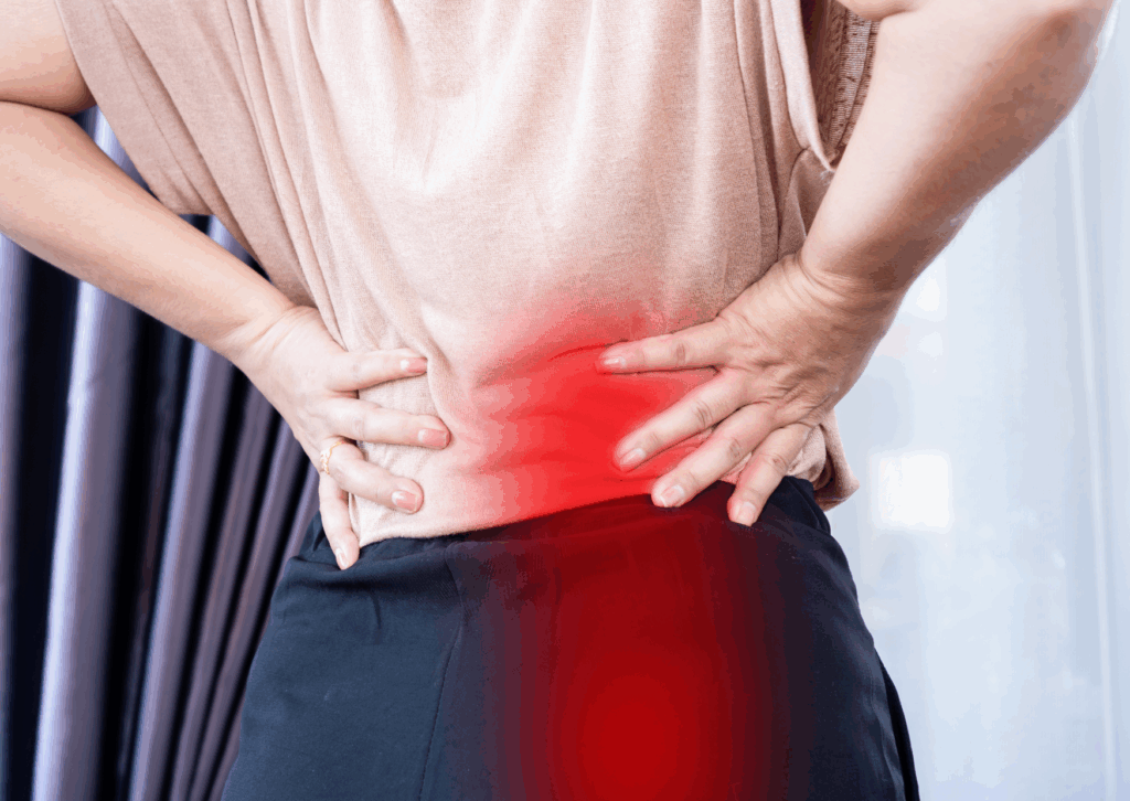 paziente che soffre di lombo-sciatalgia con le mani sui fianchi per il dolore che verrà trattata dai fisioterapisti della FisioClinic del centro Colombo